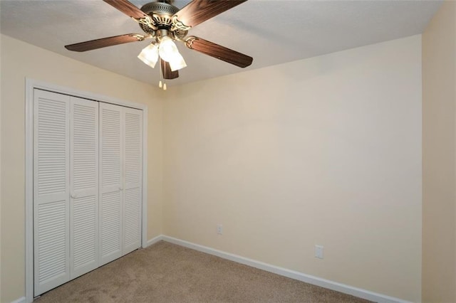 unfurnished bedroom featuring light carpet, ceiling fan, and a closet