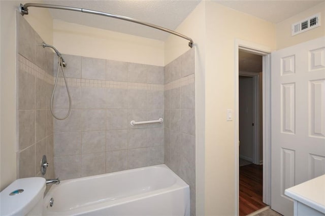 full bathroom featuring vanity, hardwood / wood-style floors, toilet, and tiled shower / bath