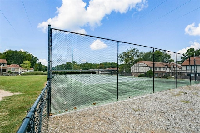 view of tennis court featuring a lawn