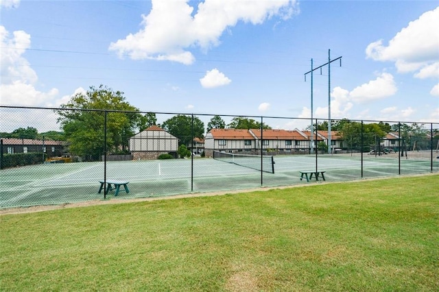 view of tennis court with a lawn