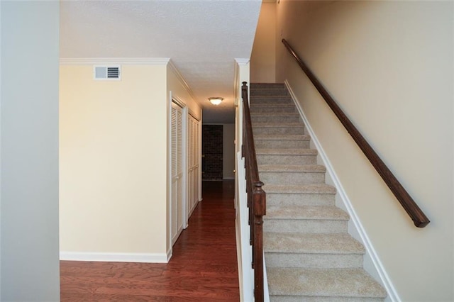 stairs featuring hardwood / wood-style flooring and ornamental molding