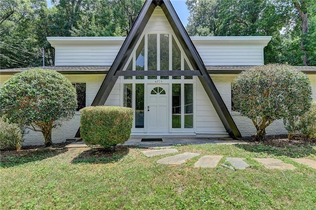 tudor home with a front lawn