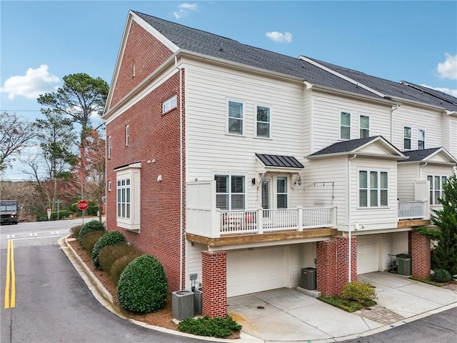 view of property with cooling unit, a balcony, and a garage