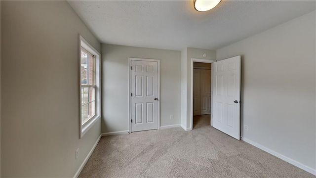 unfurnished bedroom with baseboards, carpet, and a textured ceiling