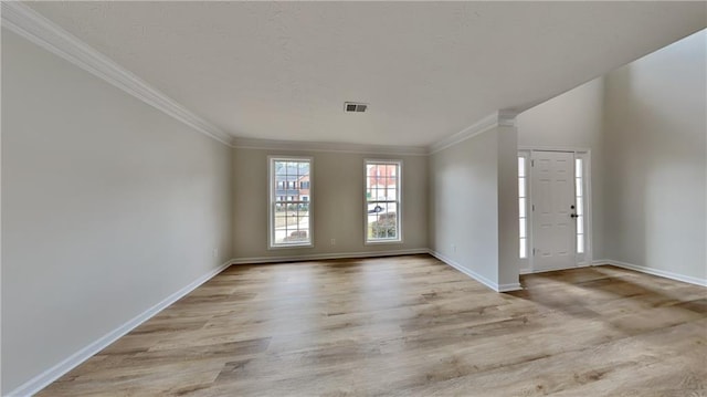 interior space featuring visible vents, baseboards, wood finished floors, and ornamental molding