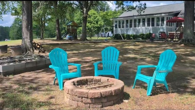 exterior space with an outdoor fire pit and a playground