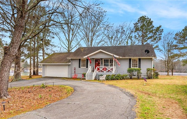 ranch-style home featuring a porch, a front yard, a garage, and driveway