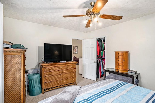 carpeted bedroom with a textured ceiling and a ceiling fan