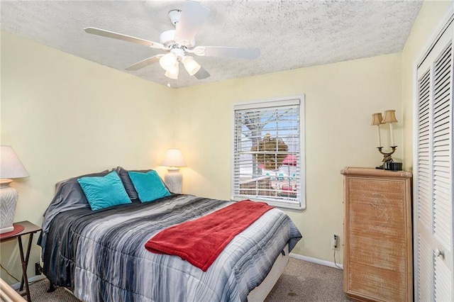 bedroom with a textured ceiling, carpet flooring, a closet, and baseboards