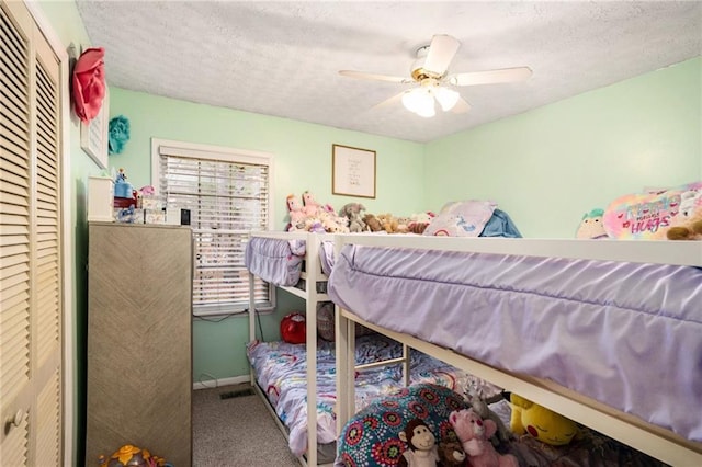 bedroom with carpet flooring, a textured ceiling, baseboards, and ceiling fan
