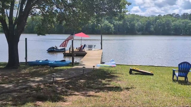 dock area with a water view and a lawn