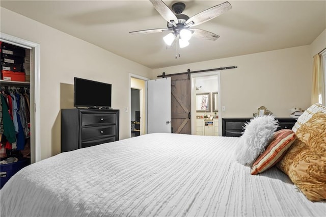 4025 Cheoah Dr, Douglasville, GA 30135 - bedroom featuring a barn door, a walk in closet, a closet, connected bathroom, and ceiling fan