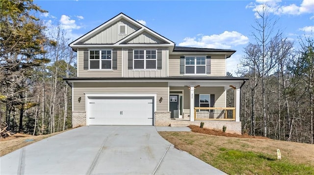 craftsman inspired home featuring driveway, a garage, covered porch, a front lawn, and board and batten siding