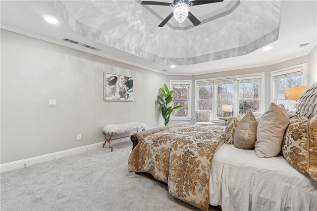 bedroom featuring a ceiling fan, baseboards, a tray ceiling, carpet, and crown molding