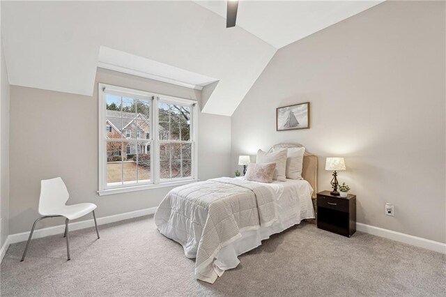 bedroom with ceiling fan, baseboards, vaulted ceiling, and light colored carpet