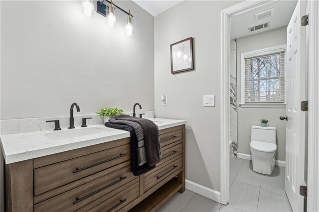 bathroom with visible vents, toilet, vanity, tile patterned flooring, and baseboards