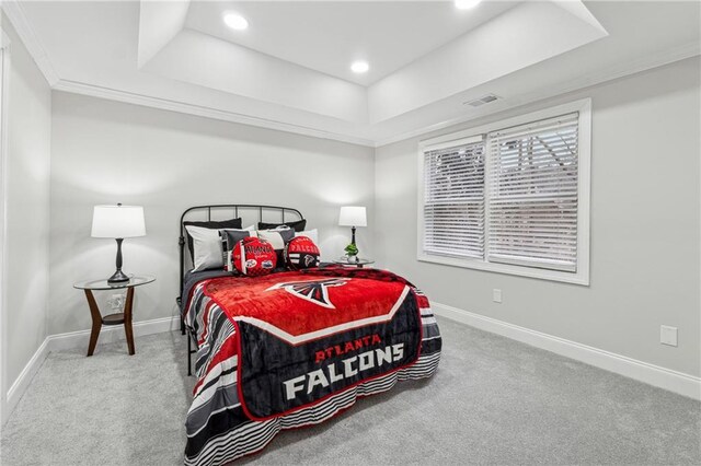 carpeted bedroom featuring ornamental molding, a tray ceiling, visible vents, and baseboards