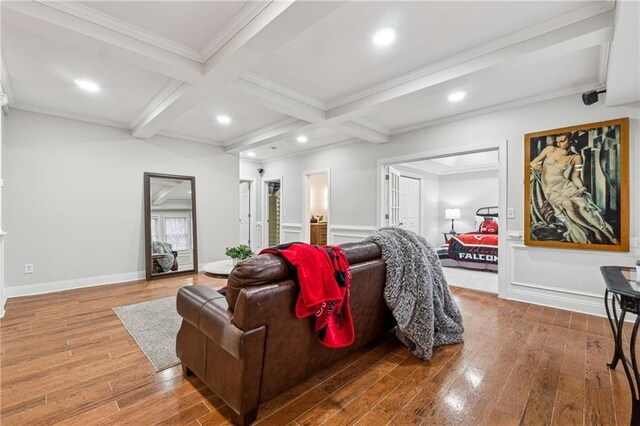 living area with beam ceiling, coffered ceiling, and wood finished floors