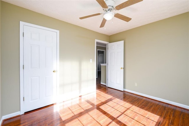 1188 Pine Acre Dr, Sugar Hill, GA 30518 - unfurnished bedroom with wood finished floors, baseboards, and ceiling fan