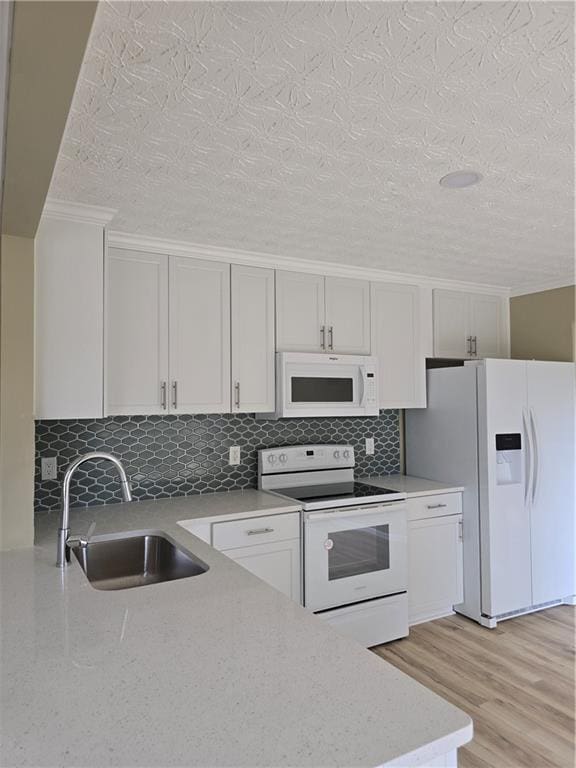 1188 Pine Acre Dr, Sugar Hill, GA 30518 - kitchen with white appliances, a sink, tasteful backsplash, a textured ceiling, and light wood finished floors