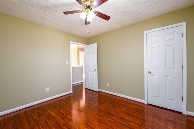 1188 Pine Acre Dr, Sugar Hill, GA 30518 - unfurnished bedroom featuring baseboards, wood finished floors, a textured ceiling, and a ceiling fan