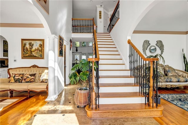 staircase with ornamental molding and ornate columns