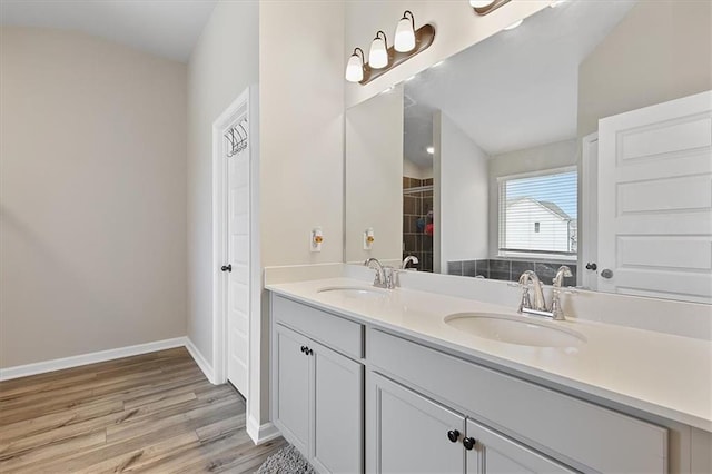 bathroom with vanity, wood-type flooring, and lofted ceiling