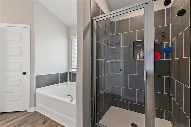 bathroom featuring lofted ceiling, plus walk in shower, and hardwood / wood-style flooring