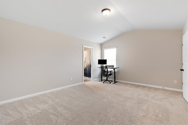 home office with lofted ceiling and light carpet