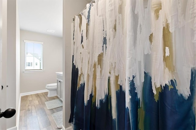 bathroom featuring vanity, hardwood / wood-style floors, curtained shower, and toilet