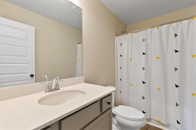 bathroom with toilet, curtained shower, and vanity