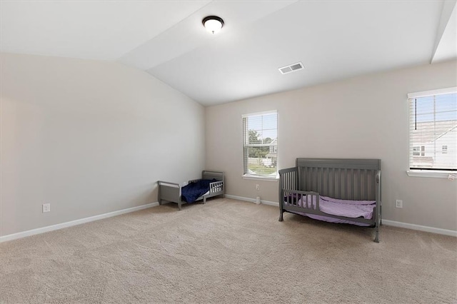 carpeted bedroom featuring multiple windows and lofted ceiling