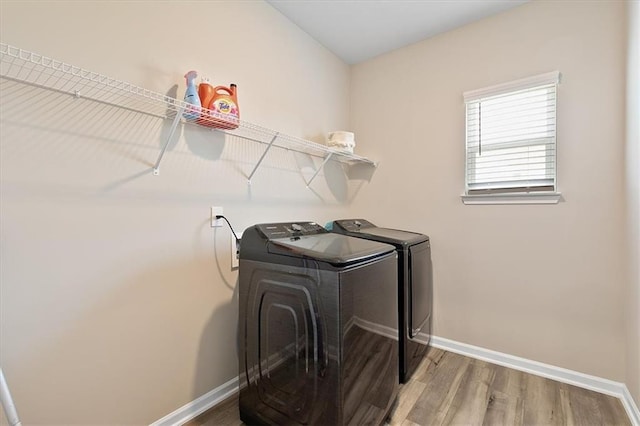 washroom featuring wood-type flooring and washing machine and clothes dryer