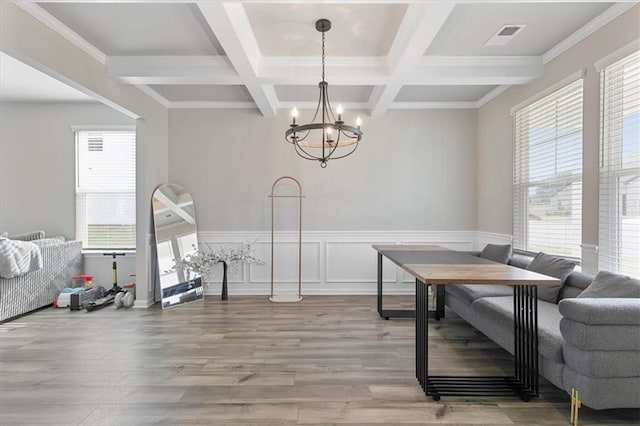 dining space featuring hardwood / wood-style floors, beam ceiling, a chandelier, and coffered ceiling