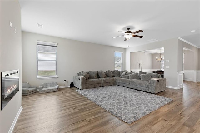 living room featuring hardwood / wood-style flooring and ceiling fan with notable chandelier