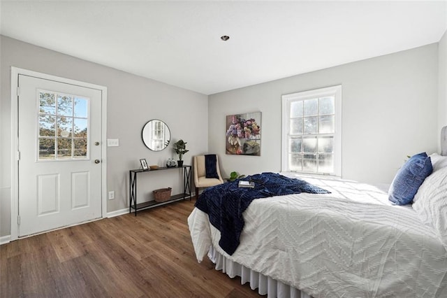 bedroom with multiple windows and dark hardwood / wood-style flooring