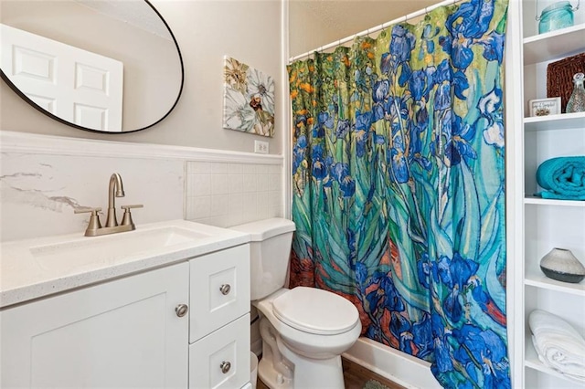 bathroom featuring toilet, vanity, tile walls, and built in shelves