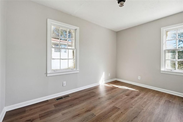 unfurnished room with dark hardwood / wood-style flooring