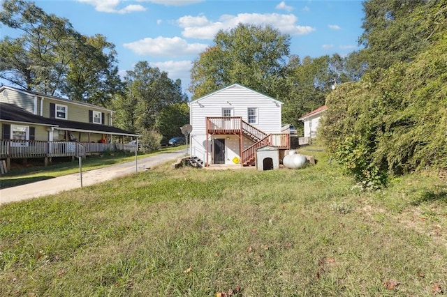 view of front of home featuring a wooden deck, a front lawn, and a carport