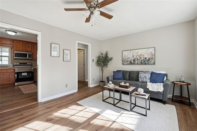 living room featuring ceiling fan and hardwood / wood-style flooring