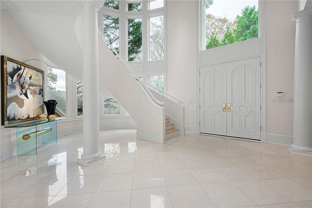 tiled entryway featuring a high ceiling and decorative columns