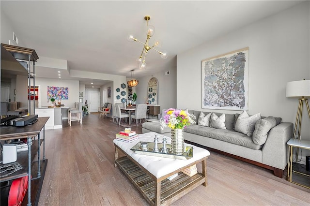 living room with hardwood / wood-style flooring and a notable chandelier