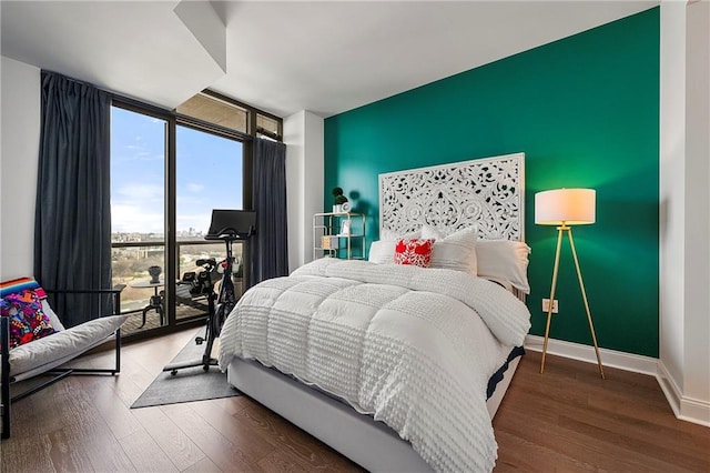 bedroom featuring dark wood-type flooring and expansive windows