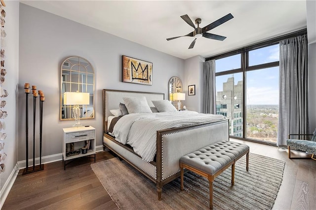 bedroom featuring dark wood-type flooring, expansive windows, ceiling fan, and access to outside