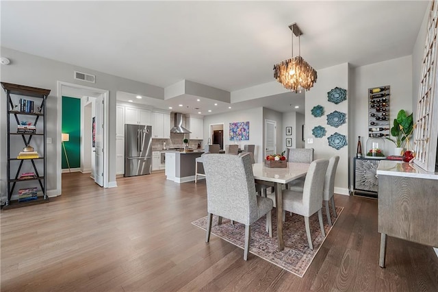 dining space featuring hardwood / wood-style flooring and a notable chandelier