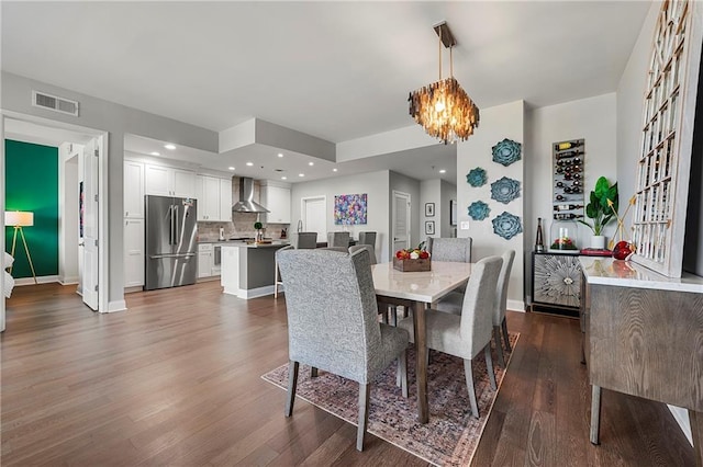 dining area with dark hardwood / wood-style flooring and a notable chandelier