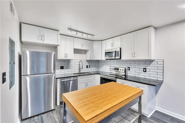 kitchen featuring sink, stainless steel appliances, tasteful backsplash, dark hardwood / wood-style flooring, and white cabinets