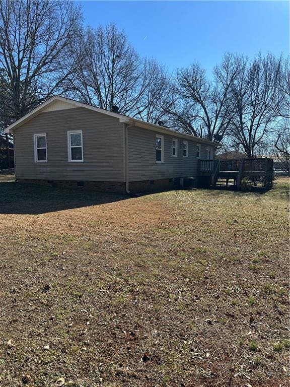 back of property with a deck and a yard