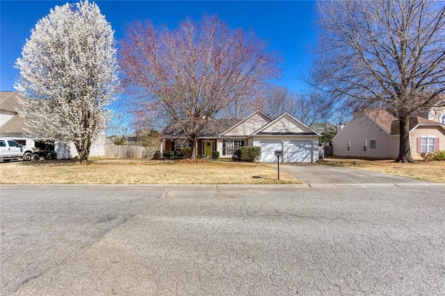 view of front facade featuring a garage, a front yard, and driveway