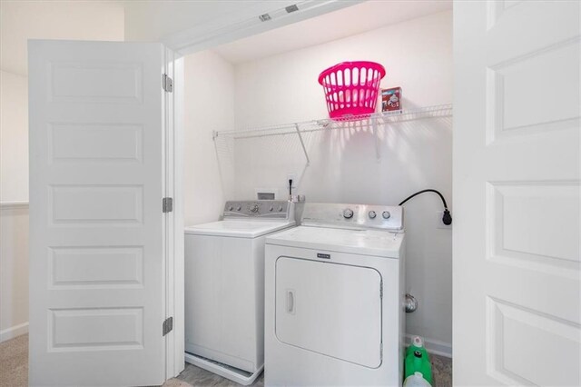 clothes washing area featuring separate washer and dryer